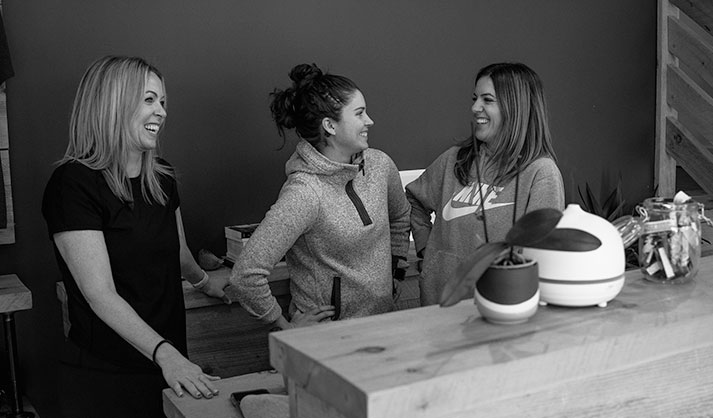 three women talking at yoga studio